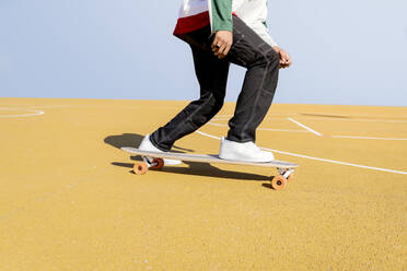 Young man riding skateboard on sports court - JCCMF01723
