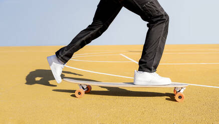 Young man skateboarding on sports court - JCCMF01724