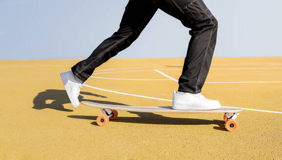 Junger Mann fährt auf dem Sportplatz Skateboard - JCCMF01724