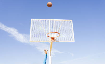 Sportlerin spielt Basketball unter dem Himmel - JCCMF01727