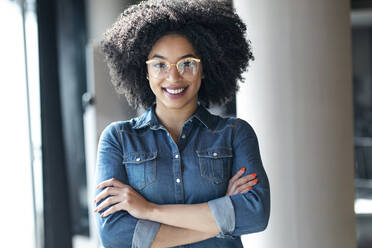 Young businesswoman with arms crossed smiling - JSRF01482