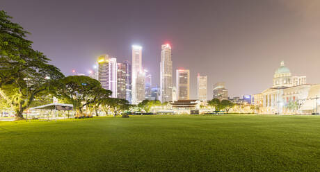 Singapur, Padang-Feld bei Nacht mit beleuchteter Stadtsilhouette im Hintergrund - AHF00341