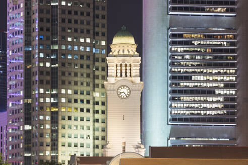 Singapur, Uhrenturm des Victoria Theatre und der Concert Hall bei Nacht mit Wolkenkratzern im Hintergrund - AHF00350