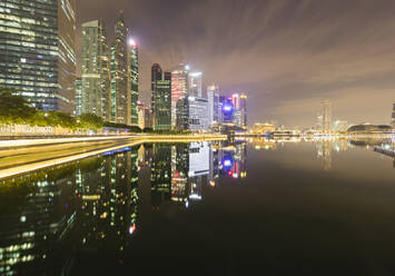 Singapur, Wolkenkratzer in der Innenstadt, die sich in der Marina Bay bei Nacht spiegeln - AHF00354