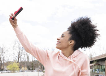 Woman taking selfie through smart phone outdoors - JCCMF01754