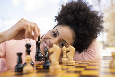Frau spielt Schach am Tisch - JCCMF01792