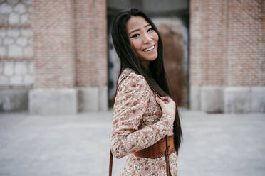 Smiling woman with long hair in city - EBBF03201