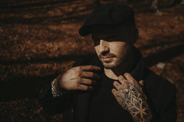 Hipster man with beret in forest during autumn - GMLF01136