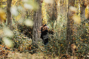 Frau beim Fotografieren im Wald im Herbst - MRRF00995