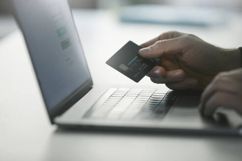 Man making online payment through credit card on laptop - PSBHF00015