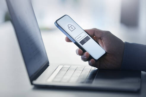 Man holding smart phone with data security on display at office - PSBHF00016