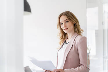 Schöne Geschäftsfrau mit Dokumenten im Büro stehend - DIGF15041