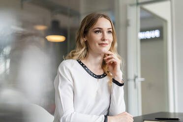 Nachdenkliche Unternehmerin mit Blick ins Büro - DIGF15064