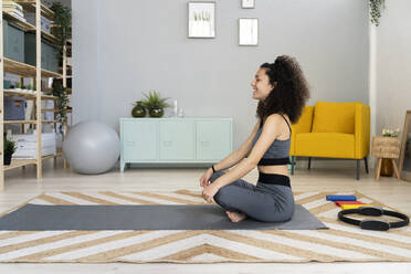 Smiling woman meditating at home - GIOF12137