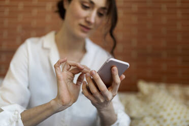 Frau benutzt Mobiltelefon zu Hause - VABF04301