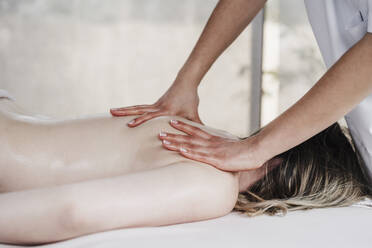 Female therapist massaging patient in clinic - EBBF03279