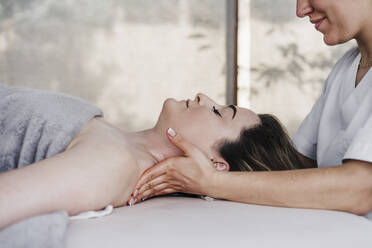 Smiling physiotherapist massaging patient in hospital - EBBF03282