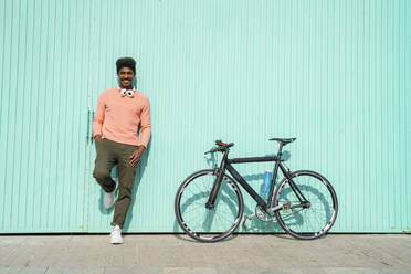 Lächelnder Mann mit Fahrrad an einem sonnigen Tag - AFVF08527