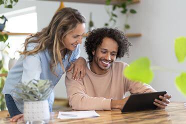 Businessman and woman looking at digital tablet together - SBOF03778