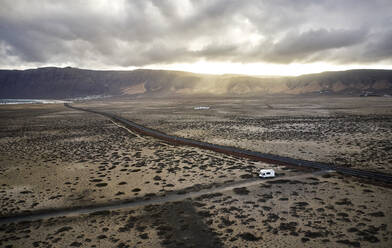 Spanien, Kanarische Inseln, Luftaufnahme eines Wohnmobils auf einer Schotterstraße auf der Insel Lanzarote - CVF01685