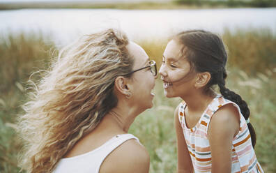 Happy mother and daughter looking at each other - AZF00235