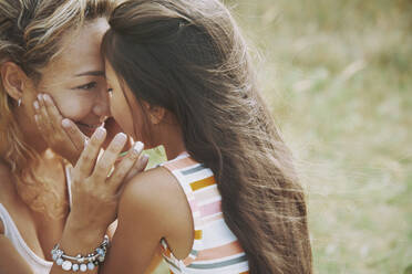 Daughter with hands on mother's cheek - AZF00241