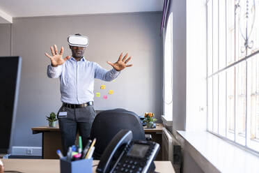 Männlicher Unternehmer mit Virtual-Reality-Headset im Büro - WPEF04284