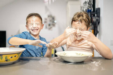 Happy siblings playing with flour and water at home - AMPF00208