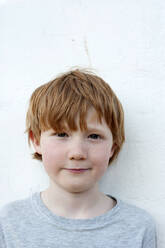 Redhead boy in front of wall outdoors - GISF00793