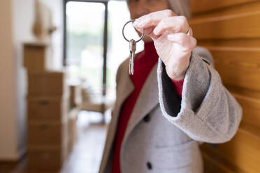 Mature woman showing new house keys at doorway - JCCMF01903