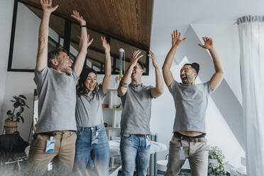 Cheerful male and female physiotherapist with arms raised having fun in practice - MFF07738