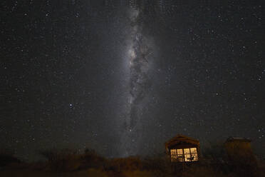 South hemisphere Milky Way and a small illuminated hut, Namibia, Africa - RHPLF19498