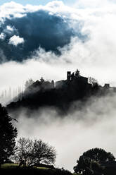 Silhouette des Dorfes Montefioralle im frühen Morgennebel, als die Sonne durchbricht, Toskana, Italien, Europa - RHPLF19508