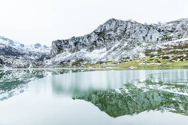 Erstaunliche Landschaft von rauen schweren Bergkette mit Hängen in Schnee und kalten gefrorenen See auf dem Boden auf klaren Wintertag - ADSF22576