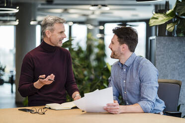 Geschäftsleute diskutieren am Tisch bei einem Treffen am Arbeitsplatz - DIGF15156