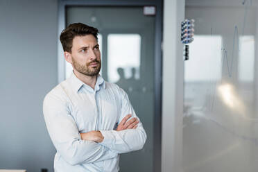 Businessman examining graph on whiteboard while working at office - DIGF15186