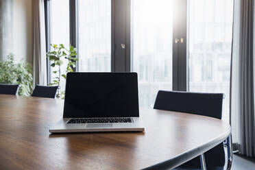 Laptop on table in board room at modern work place - DIGF15299