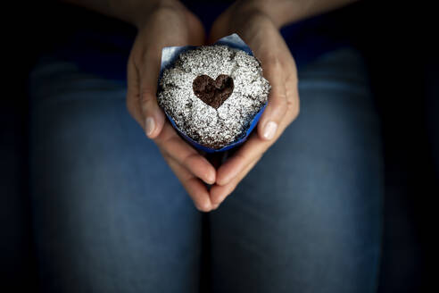 Hands of woman holding Valentines Day muffin - MBEF01468