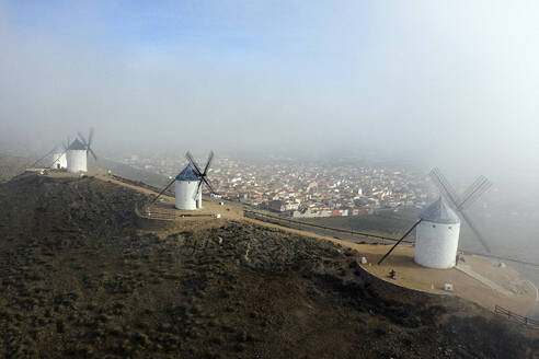 Spain, Province of Toledo, Consuegra, Aerial view of historical windmills with town in background - DSGF02405