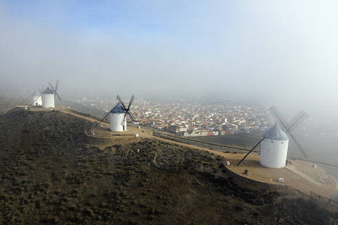 Spanien, Provinz Toledo, Consuegra, Luftaufnahme von historischen Windmühlen mit Stadt im Hintergrund - DSGF02405