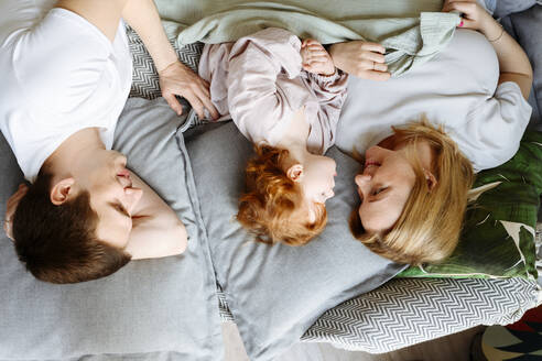 Familie auf dem Bett liegend zu Hause - VYF00534