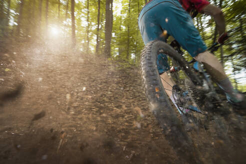 Man drifting bicycle on dirt road in forest - RNF01331