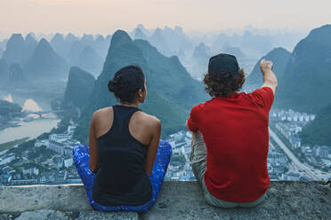 Ein Paar genießt die Aussicht über die Stadt Yangshuo in China - CAVF93798