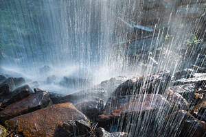 Schuss von hinten Wasserfall Crashing on Rocks Backlit Abstract - CAVF93824