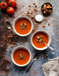 Overhead flach legen von Schalen von Tomatensuppe auf grauem Stein Hintergrund. - CAVF93851