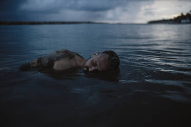 Mittlerer erwachsener Mann schwimmt auf dem Wasser - GMLF01161