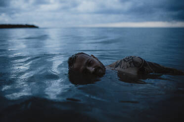 Hipster Mann im Wasser bei Regen - GMLF01162