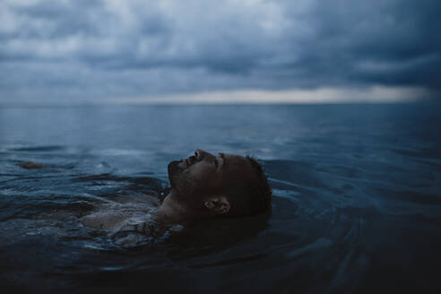 Mann schwimmt auf Wasser im Meer - GMLF01163