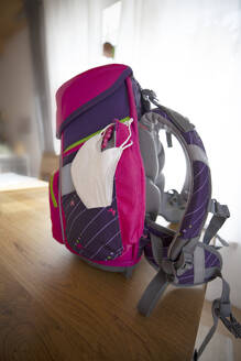 Rucksack mit Gesichtsschutzmaske am Tisch - GAF00175