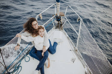 Smiling mother and daughter enjoying vacation on sailboat - GMLF01164